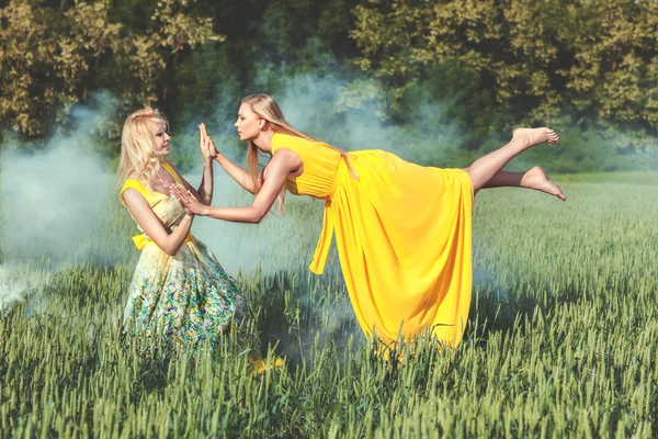 Två kvinnor, en levitates. — Stockfoto
