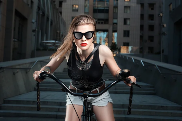 Vrouw in zonnebril op de fiets. — Stockfoto