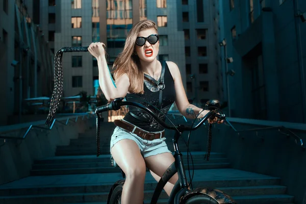 Mulher com chicote em uma bicicleta . — Fotografia de Stock