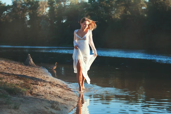 Vrouw loopt door het water van het meer. — Stockfoto