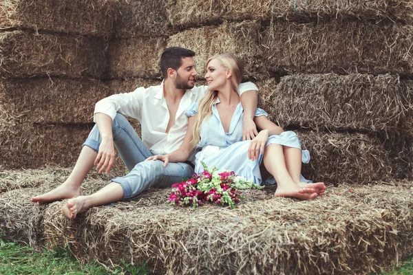 Verliefde paar trok zich terug in het stro. — Stockfoto