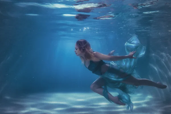 Mulher em um vestido mergulha na água. — Fotografia de Stock