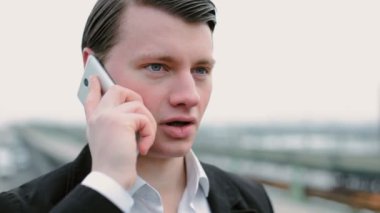 Genç bir erkek telefonda konuşuyor..