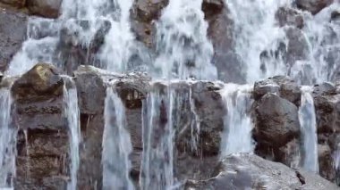 Taşların arasından akan su bir şelaledir. Nehirdeki taşların içinden su akar..