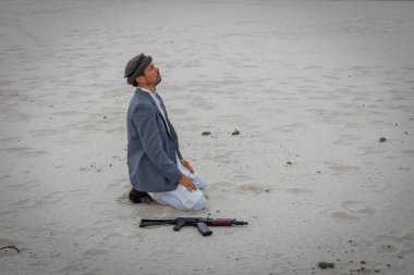 Müslüman adam dışarıda molebeny ayini yapıyor. Silahi yakinda ve savasa devam etmeye hazir..