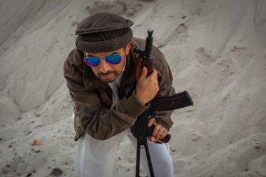 Taliban silahlarıyla terörist saldırılar planlıyor. Elinde silahlarla milli keffiyeden yapılmış başlıklı Arap erkek asker..