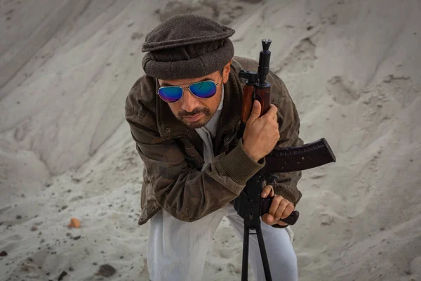 Taliban silahlarıyla terörist saldırılar planlıyor. Elinde silahlarla milli keffiyeden yapılmış başlıklı Arap erkek asker..
