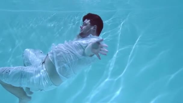 Een Man Met Een Hemd Een Korte Broek Zwemt Onder — Stockvideo