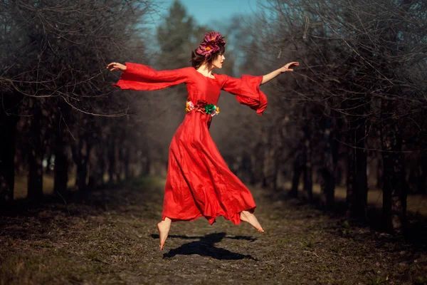 Kırmızı elbiseli kız soars. — Stok fotoğraf