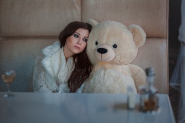Sad girl with toy bear. clipart