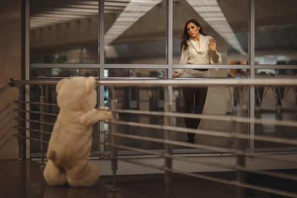 Girl says goodbye with a teddy bear. — Stock Photo, Image