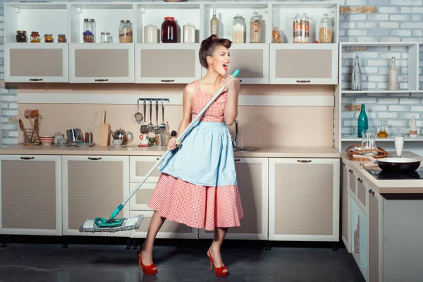 Woman sings and cleans the house. – stockfoto