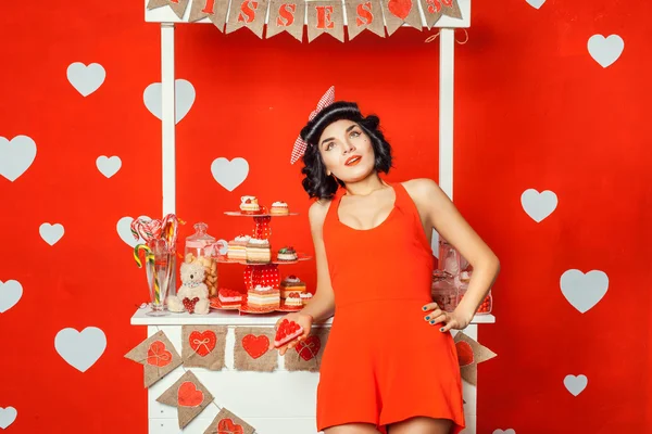 Woman in red dress holding a cake and dreams. — Stock Photo, Image