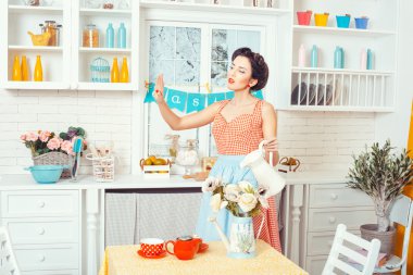 Çiçekleri sulayan kadın.