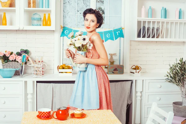 A lány a konyhában, virágok. — Stock Fotó
