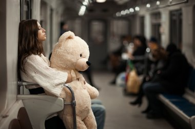 Girl with bear in a subway car. clipart