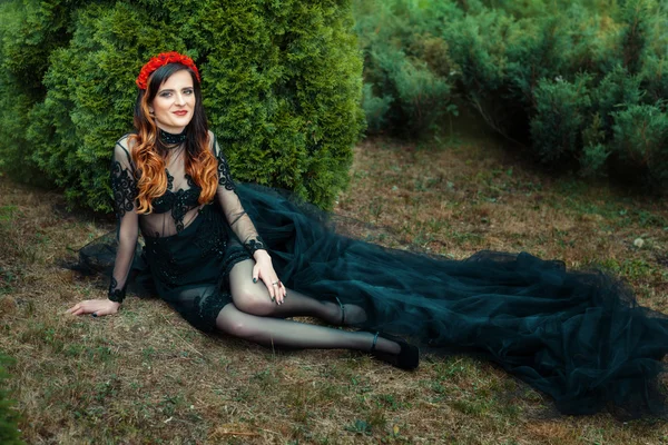 On the grass in a park beautiful girl sitting. — Stock Photo, Image