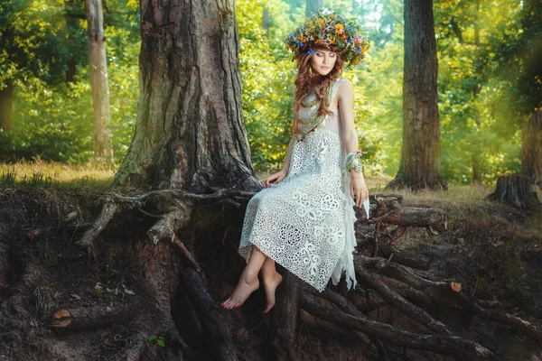 Menina senta-se em uma árvore na floresta de fadas . — Fotografia de Stock