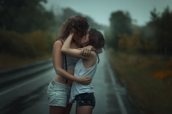 Ragazze in piedi sotto la pioggia sulla strada . — Foto Stock