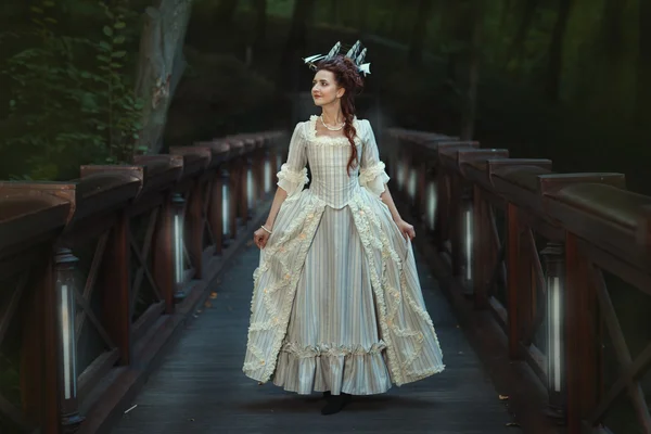 A menina em um vestido de bola velho andando na ponte . — Fotografia de Stock