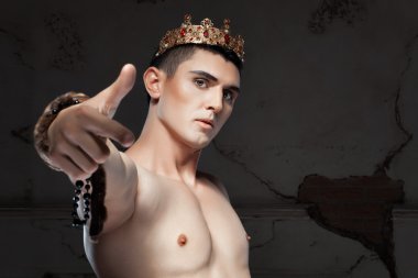 Young man with crown on the head pointing her finger. clipart