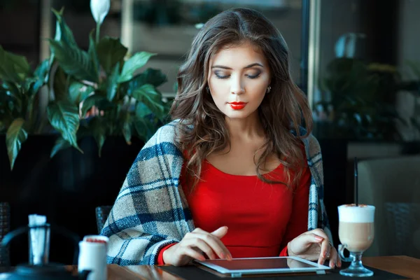 Girl wrapped  blanket sitting and working on a tablet computer. — Stock Photo, Image