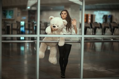 Behind the glass is a girl with  sad face.