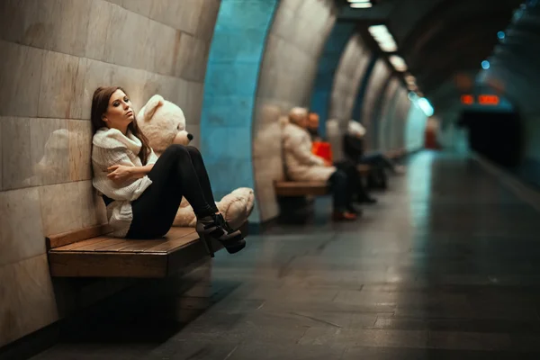 Грустная женщина сидит на скамейке в метро . — стоковое фото
