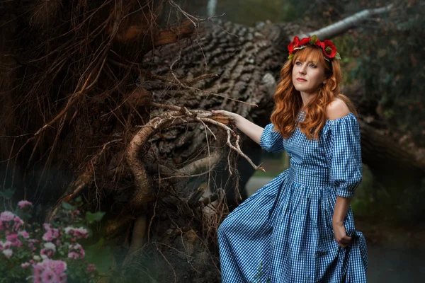 Woman standing near the tree roots like a fairy tale. — Stok fotoğraf