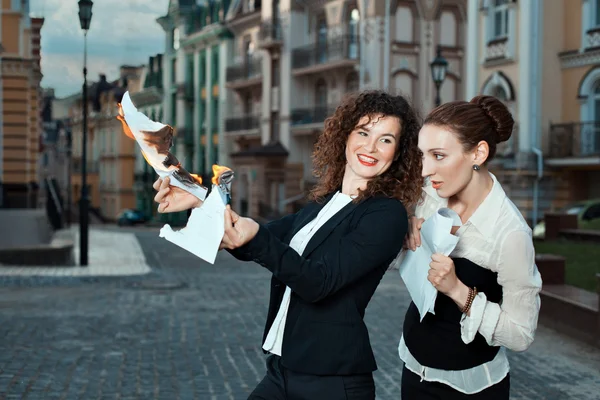 Girl burns the papers a watching other girl. — Stock Photo, Image