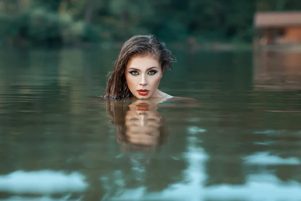 Girl's gezicht gluren uit het water. — Stockfoto