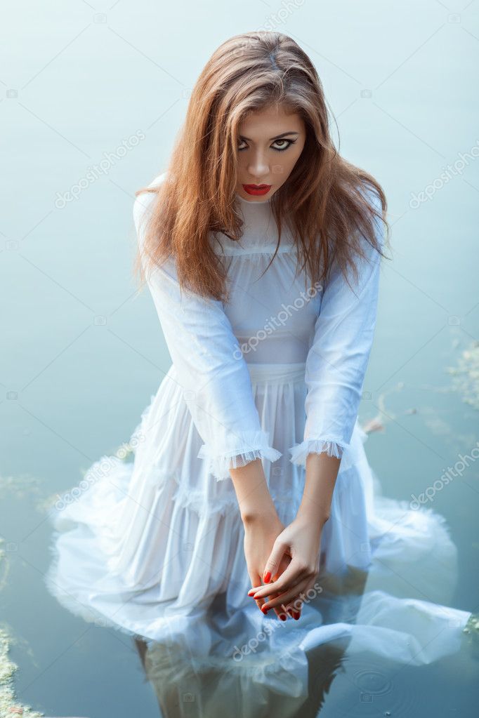 Beautiful girl standing in the water dress.