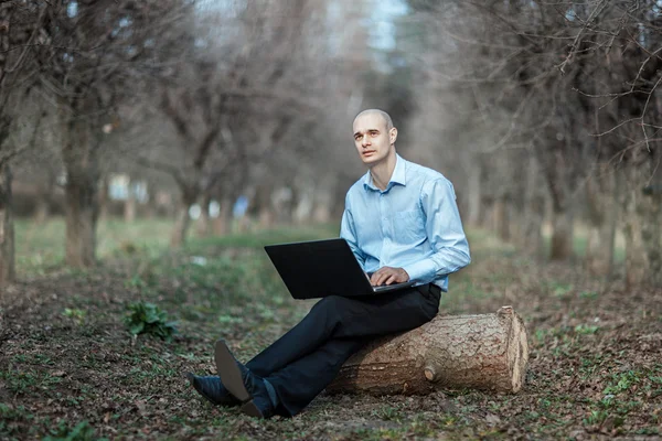 Człowiek z marzy twarz pracuje w parku laptopa. — Zdjęcie stockowe