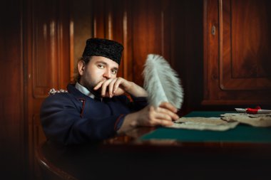  Hüzünlü gözleri olan adam bir mektup yazar.