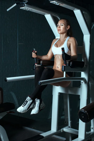 Chica ha estado en el simulador actualmente sacudiendo los músculos del estómago . —  Fotos de Stock