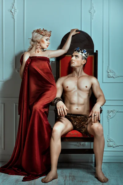 Man sits on the throne and looks at queen. — Stock Photo, Image