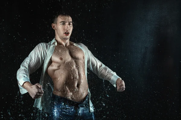 Man white shirt standing under the water droplets. — Stock Photo, Image