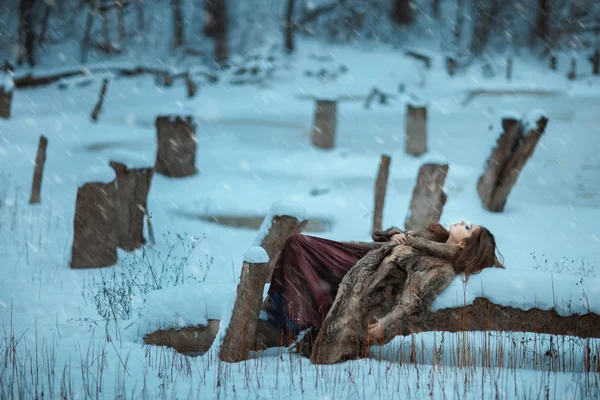 Fille couchée sur un arbre et geler en hiver . — Photo