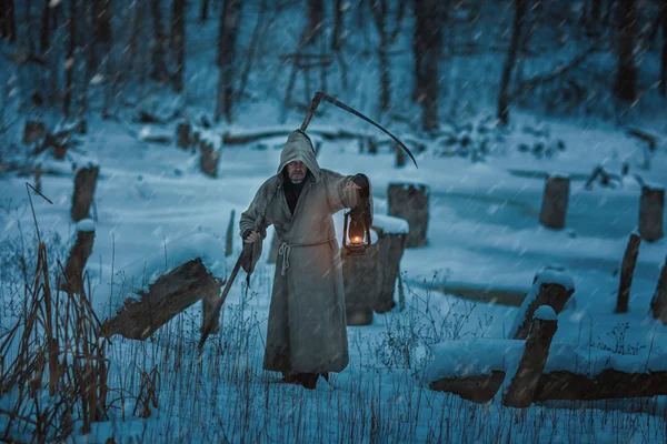 Sneeuw op het veld is man met scythe van dood. — Stockfoto