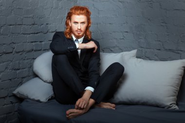 Kırmızı saç ve sakal, kanepede oturan adam.