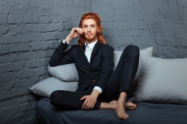 Cross-legged adam kanepede oturuyor.