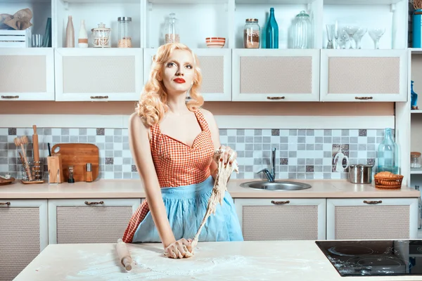 Meisje kneedt deeg in de keuken en dromen. — Stockfoto