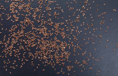 Keten tohumu koyu bir taş levhaya saçılmış.