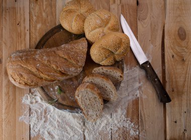 Tahta bir masanın üzerine susam tohumları serpiştirilmiş taze beyaz ekmek. en üstteki görünüm