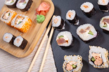 Bambu tabakta farklı suşi türleri ve siyah taş levha.