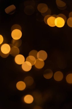 Siyah arka planda altın renkli ışıklar. Dekorasyon ya da Noel geçmişi. Boşluğu kopyala