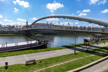 19 Nisan 2025 Krakow, Polonya. Peder Bernatek Footbridge (Kladka Ojca Bernatka), Kazimierz ve Podgorze ilçelerini birbirine bağlayan Wisla Nehri 'nin hemen güneyinde yer alır.