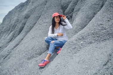 Genç Asyalı kadın, Tayland Chonburi eyaletinin Chonburi kenti yakınlarındaki Khiri Nakhon Taş Madeni 'ndeki Büyük Kanyon Chonburi' deki kar dağında oturuyor.. 