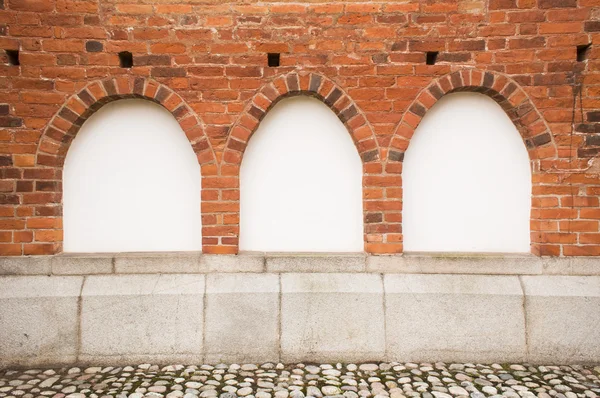 Kırmızı tuğla duvarın üstünde üç pencere eşiği
