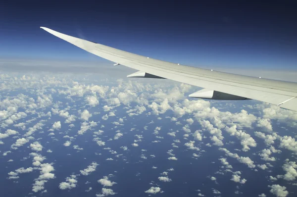 Ala de un avión volando sobre las nubes — Foto de Stock